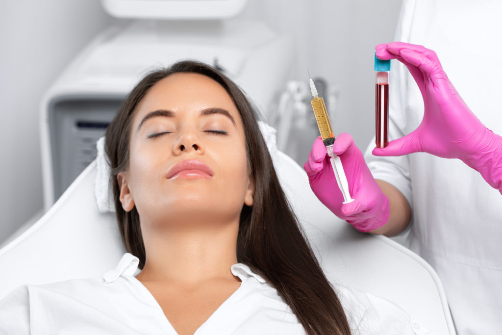 Beautician will do PRP therapy for the face against wrinkles and against hair loss of a beautiful woman in beauty salon. Doctor holds test tubes with venous blood and blood plasma.Cosmetology concept | Beauty at First Sight Med Spa in Chicago, Illinois