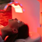a woman lying on a bed with red lights
